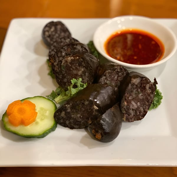 Tibetan blood sausage (gyuma) with rice, served with a spicy red dipping sauce and cucumber.